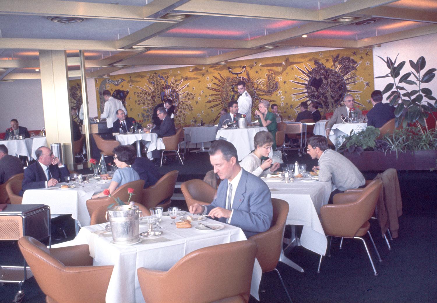 1961, les Trois Soleils, conception des aménagements André Renou et Jean-Pierre Génisset (la Crémaillère), fauteuils Conférence (Eero Saarinen), au fond de la salle la tapisserie de Jean Lurçat qui donne son nom au restaurant, 3ème étage.  ; 1961, les Trois Soleils, conception des aménagements André Renou et Jean-Pierre Génisset (la Crémaillère), au fond de la salle la tapisserie de Jean Lurçat qui donne son nom au restaurant, 3ème étage. 