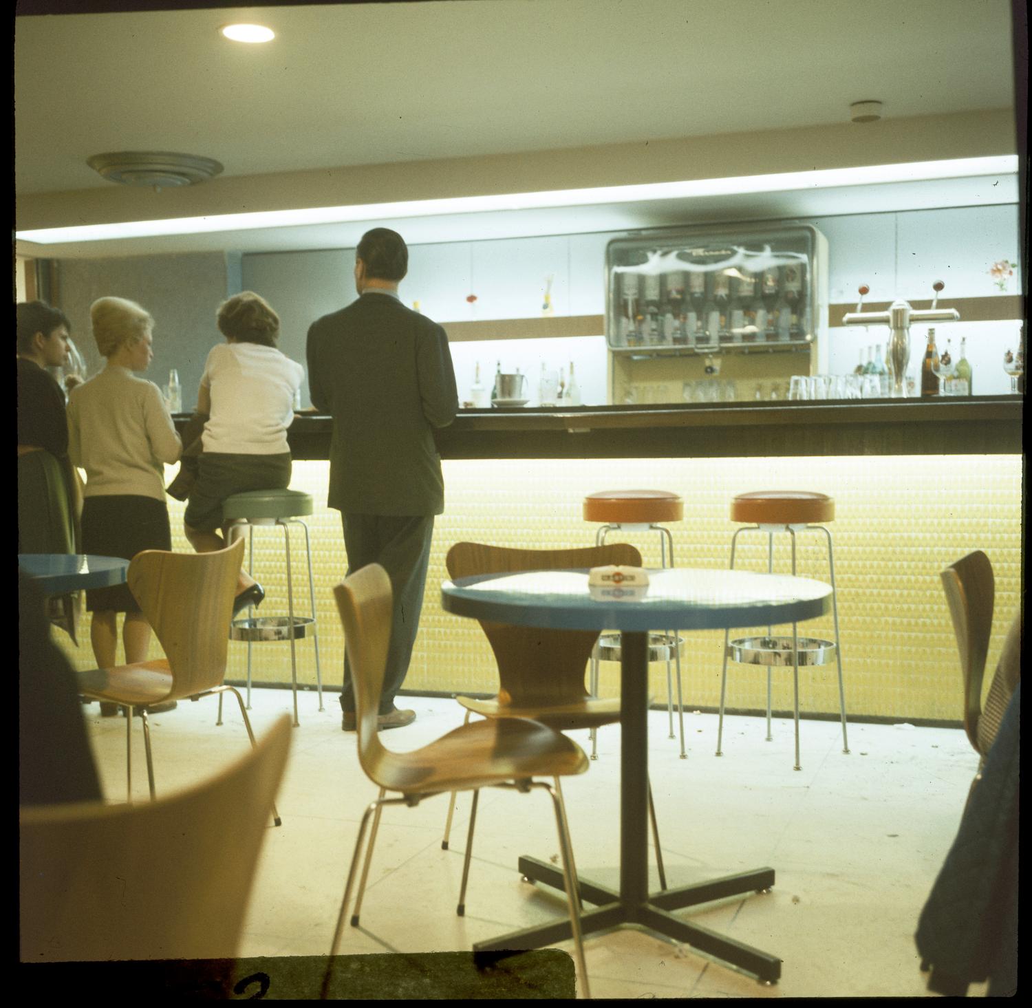 1961, le centre commercial, le bar, chaises 3107 série 7 (Arne Jacobsen), 1er sous-sol.