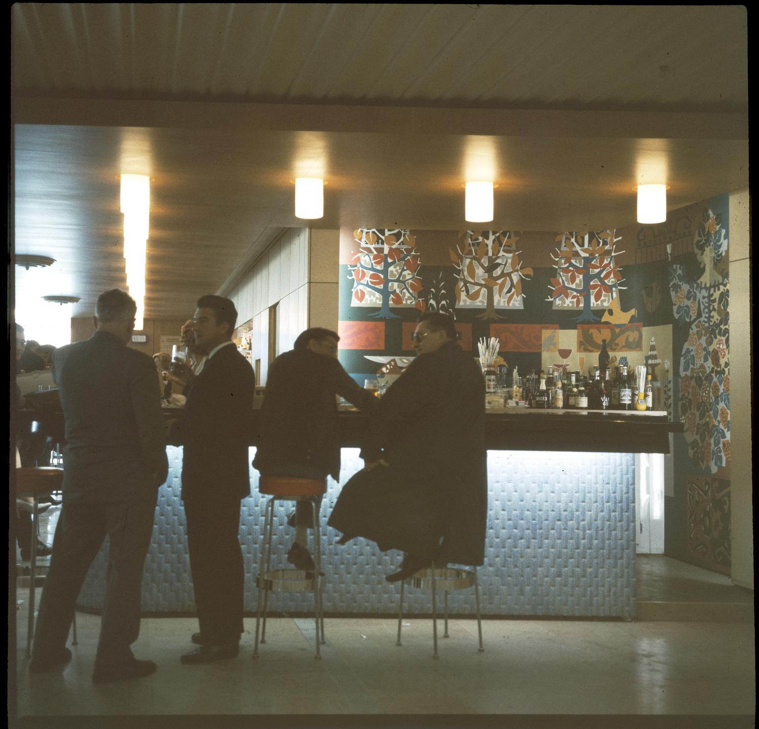 1961, le bar de la Galerie marchande, décor: panneaux en formica de Michèle Van Hout Le Beau, 1er étage.