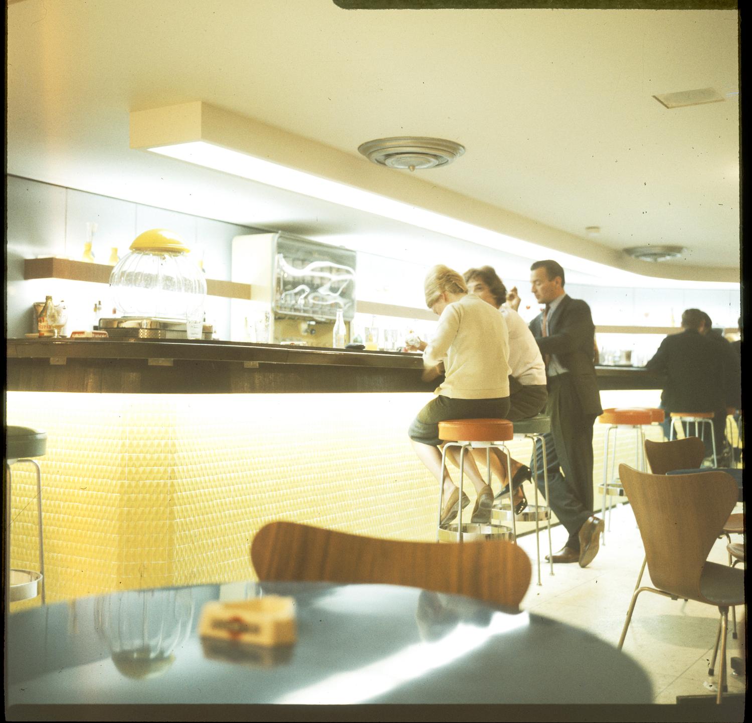 1961, le centre commercial, le bar, chaises 3107 série 7 (Arne Jacobsen), 1er sous-sol.