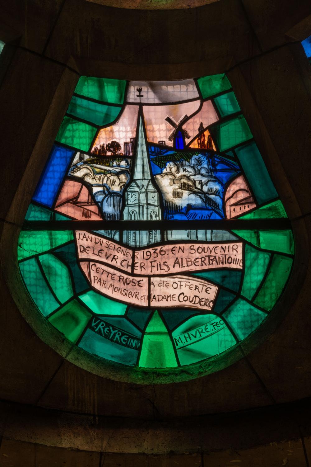 Détail du vitrail en forme de pétale représentant la ville de Sannois avec la colline du Mont Trouillet, le moulin à vent et le clocher de l'église. Il porte la dédicace des époux Couderc en souvenir de leur fils et les signatures de Valentine Reyre et de Marguerite Huré. 
