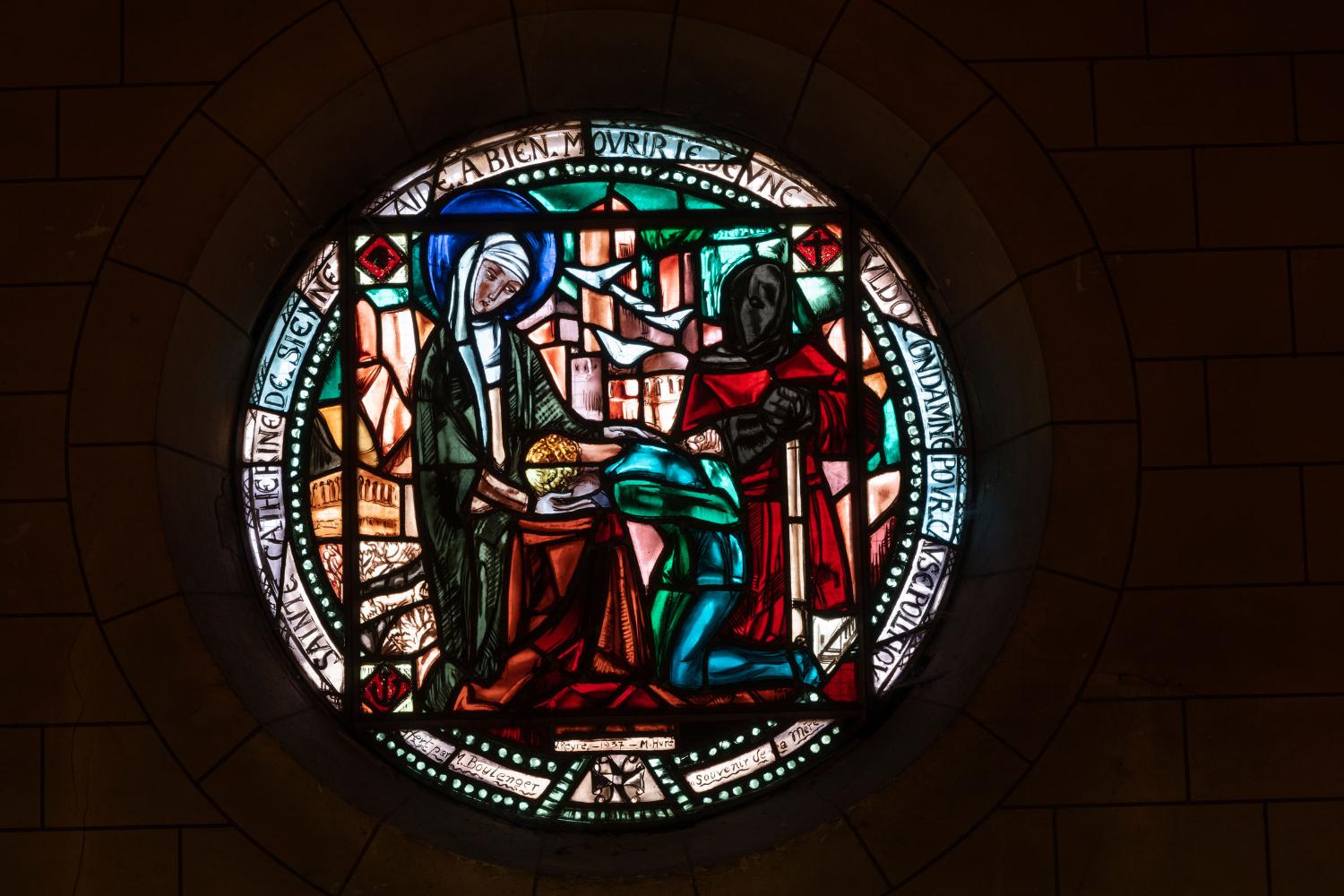 Vue générale du vitrail en forme de tondo de Valentine Reyre (1937) représentant Sainte-Catherine de Sienne soutenant le martyr Nicolo Tuldo. 