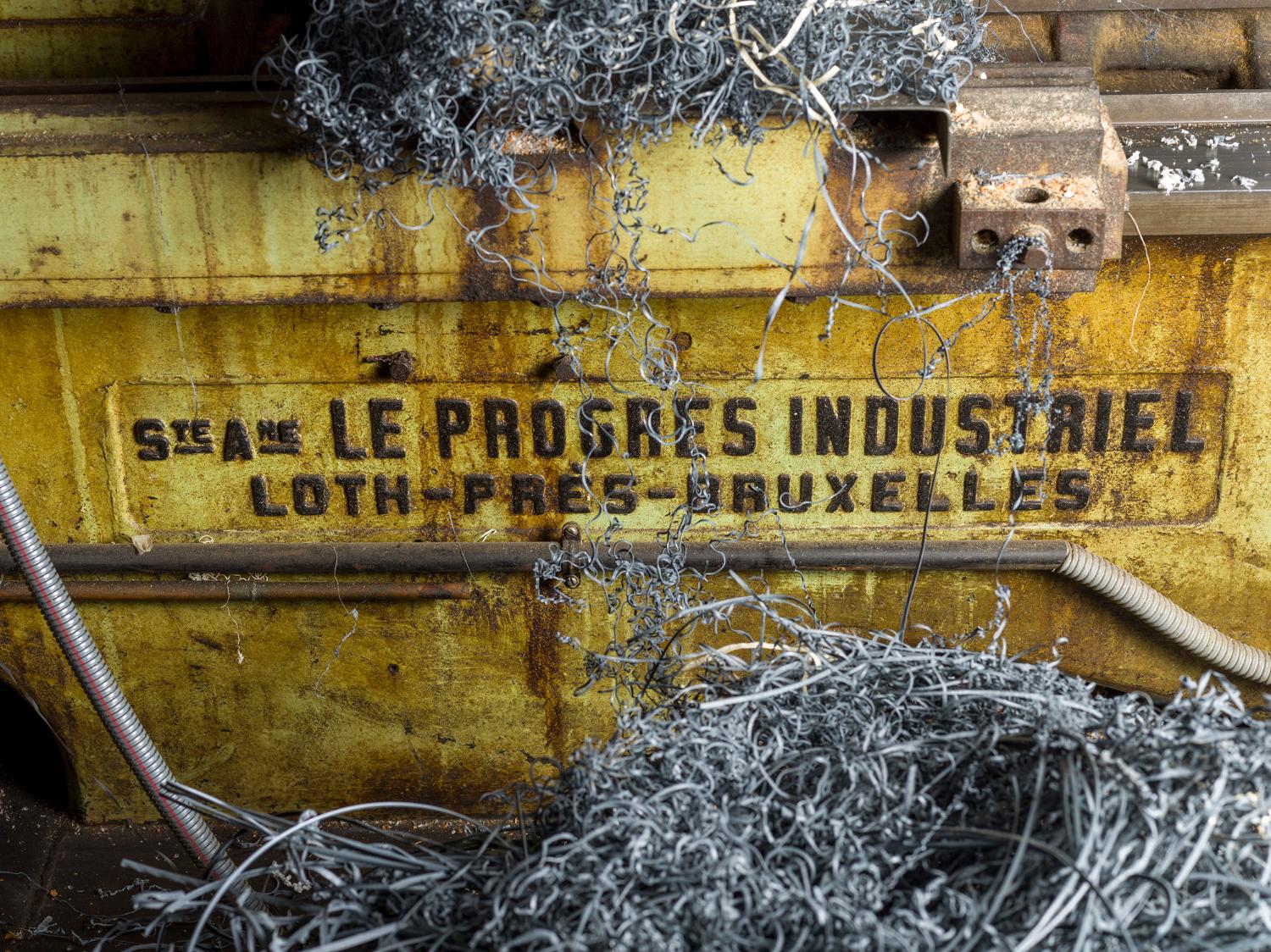 Atelier de mécanique générale (usinage). Détail de la plaque du fabricant : « Société Anonyme Le Progrès Industriel / Loth-Près-Bruxelles » du tour parallèle Le Progrès Industriel.
