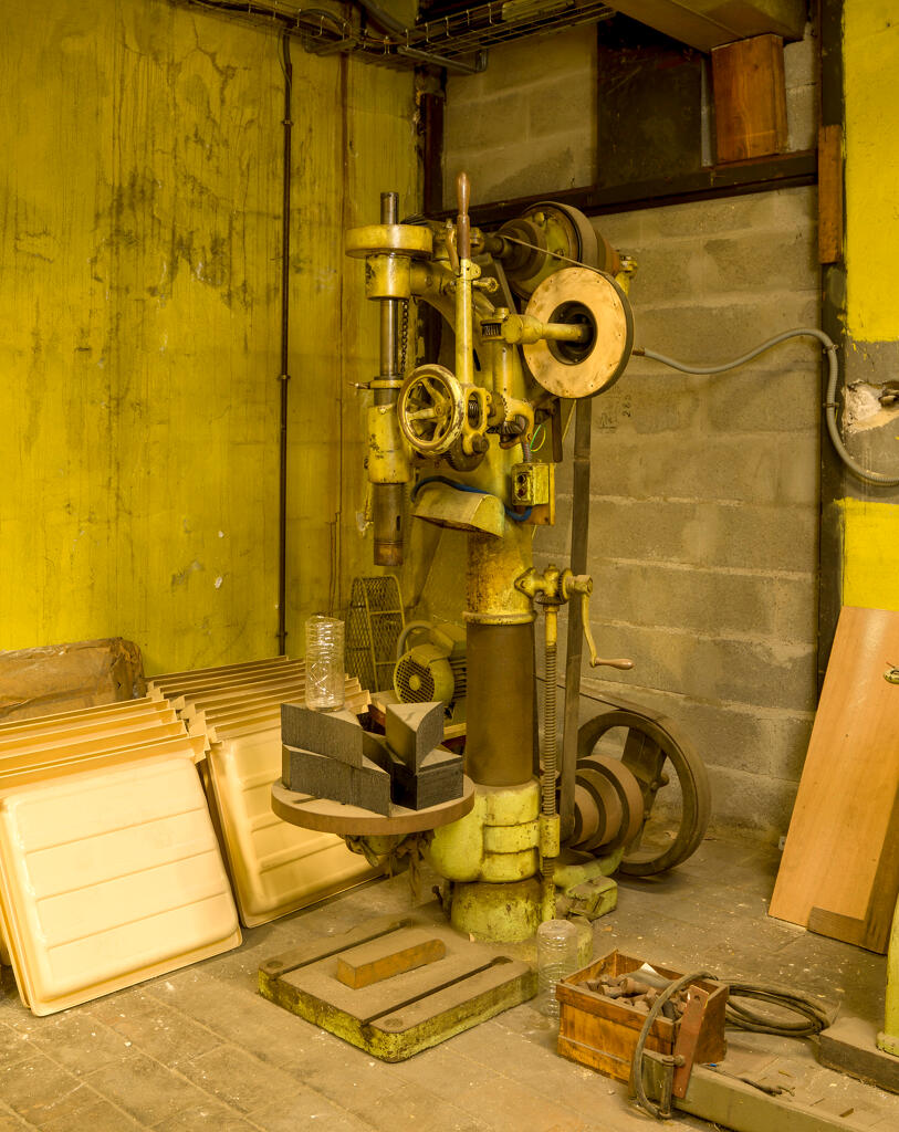 Magasin d’accessoires et de pièces détachées standards pour enceintes de confinement. Perceuse radiale (ou à colonne), transmission par courroie plate. Dommage de guerre.