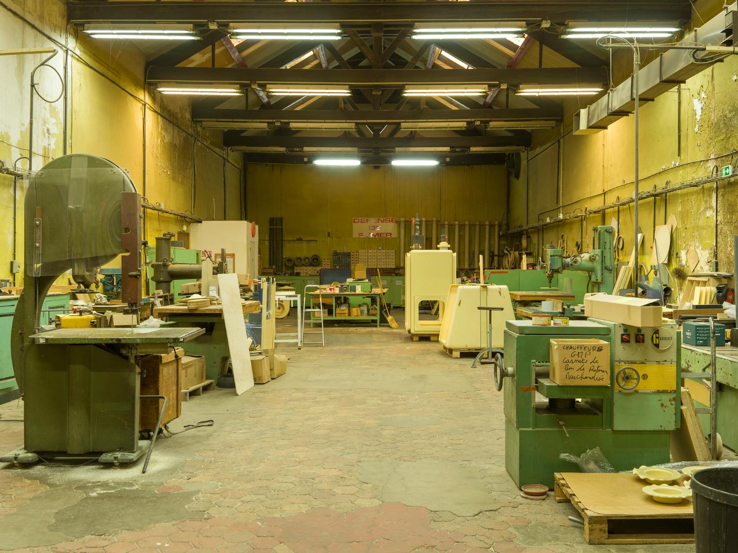 Chaudronnerie plastique, au rez-de-chaussée. Au premier plan, les machines à bois utilisées pour couper la matière plastique. À droite à l’arrière, deux enceintes de confinement en cours de fabrication. 