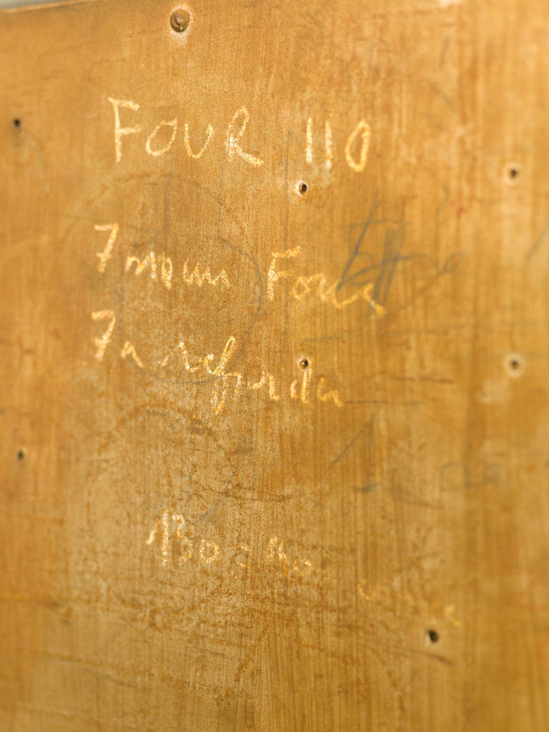 Atelier de thermoformage. Inscription à la craie sur le côté du four.