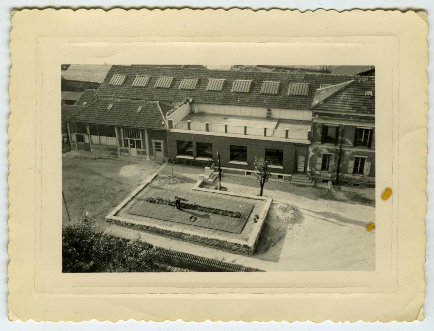 Fin 1959 : la nouvelle façade des bureaux des Ateliers de Technochimie est terminée. Vue prise depuis l'immeuble de la rue Raspail, la rue du Colombier n'est pas encore ouverte. Tirage photographique noir et blanc, 5 x 8 cm, fin 1959, sans mention d'auteur (collection Ateliers de Technochimie).  