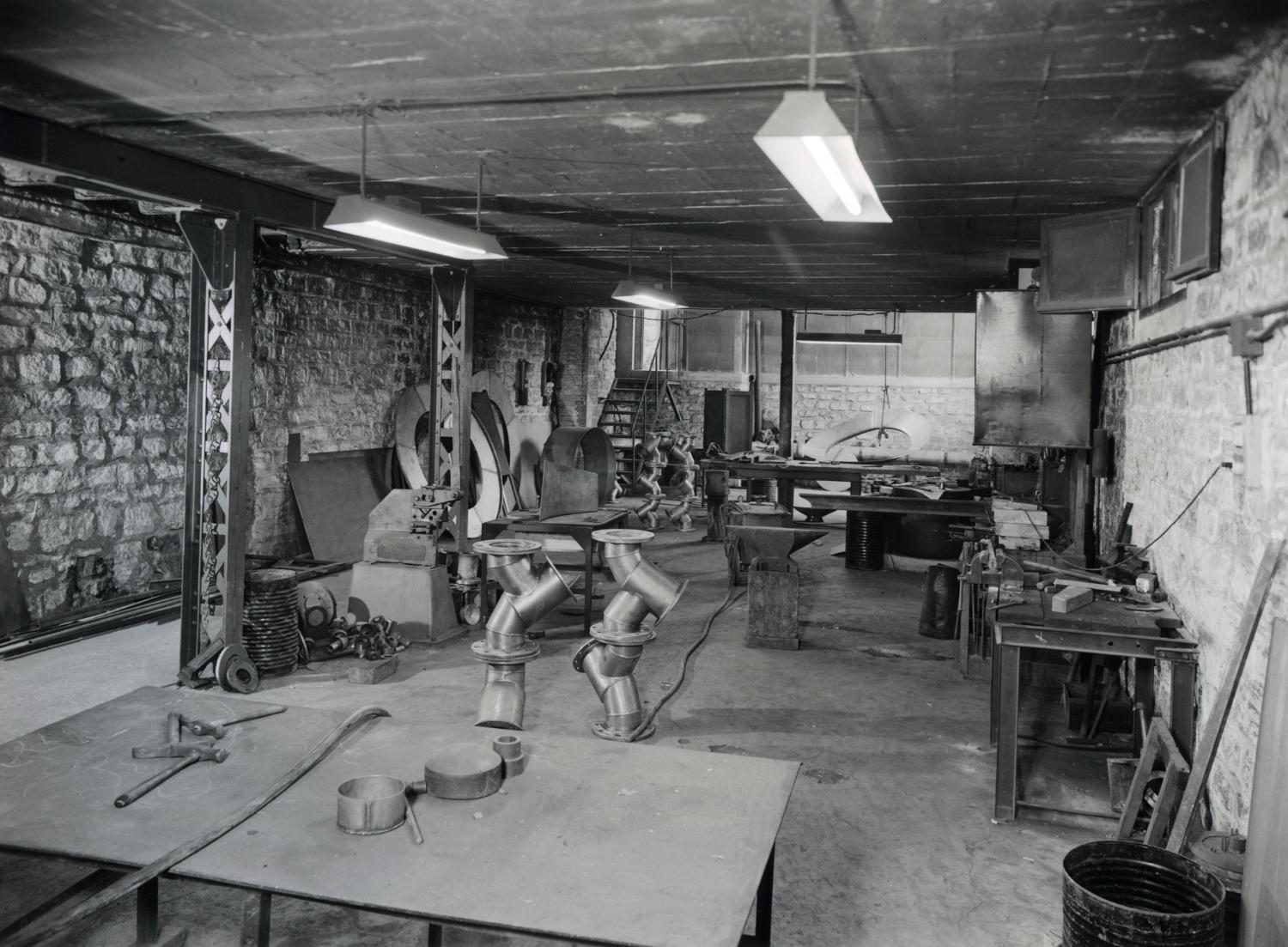 Atelier de chaudronnerie métallique, au sous-sol. Tirage photographique noir et blanc, 18 x 24 cm, années 1950, Studio Louisianne, 152 avenue Danielle Casanova, Ivry-sur-Seine (collection Ateliers de Technochimie).