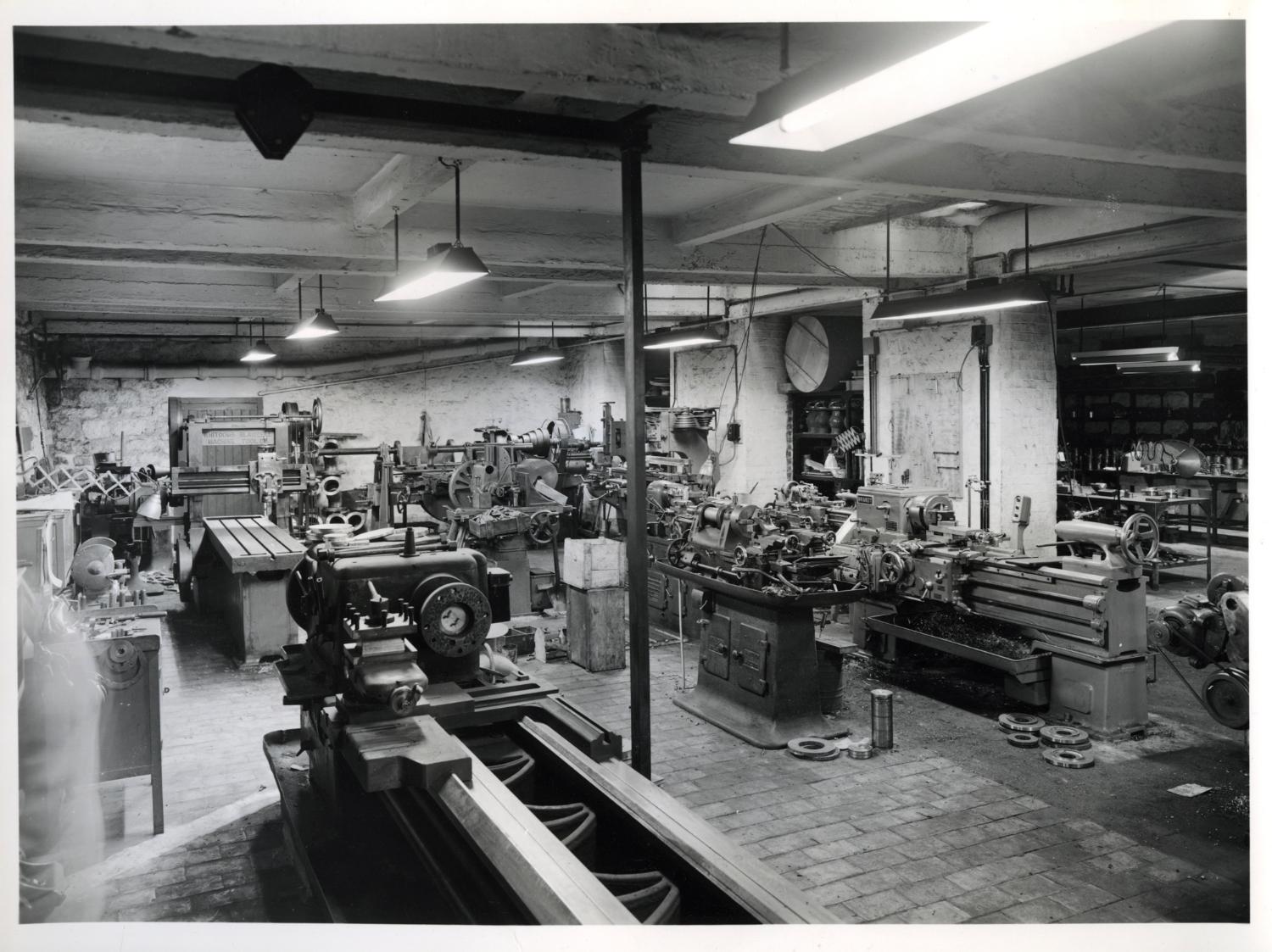 Atelier de mécanique générale (usinage), au sous-sol. Tirage photographique noir et blanc, 18 x 24 cm, années 1950, Studio Louisianne, 152 avenue Danielle Casanova, Ivry-sur-Seine (collection Ateliers de Technochimie). 