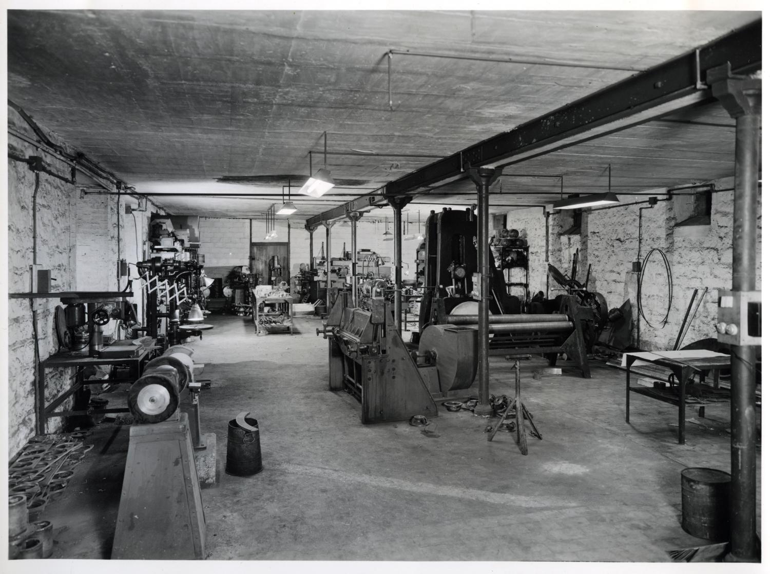 Atelier de chaudronnerie métallique, au sous-sol, aujourd'hui magasin de pièces détachées. Tirage photographique noir et blanc, 18 x 24 cm, années 1950, Studio Louisianne, 152 avenue Danielle Casanova, Ivry-sur-Seine (collection Ateliers de Technochimie).