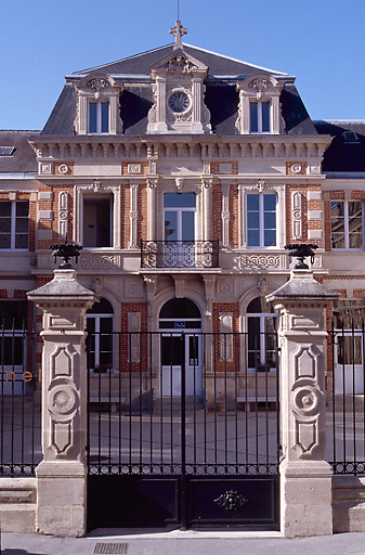 Vue de la façade principale et de la grille d'entrée.