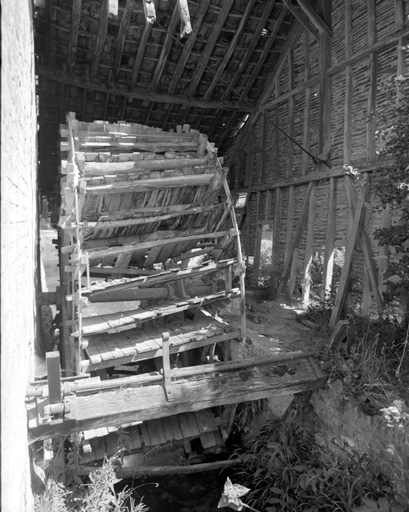 Vue du bâtiment d'eau et de la roue hydraulique verticale.