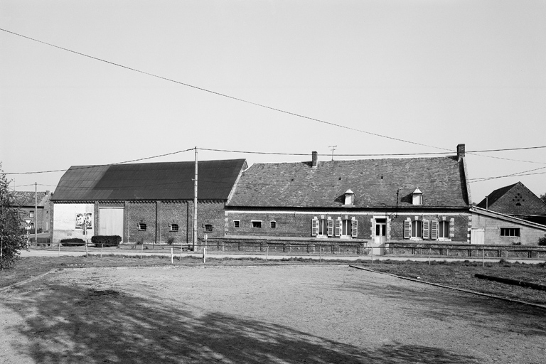 Vue de la façade du logis (construit en 1813), et du bâtiment abritant l'étable et la grange. ; Bergues-sur-Sambre, ferme (étudiée), 9 place de l'Eglise.