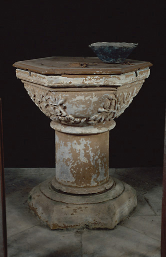Vue d'ensemble des fonts baptismaux en calcaire, datant du milieu du 13e siècle, avec réserve à eau bénite en plomb.