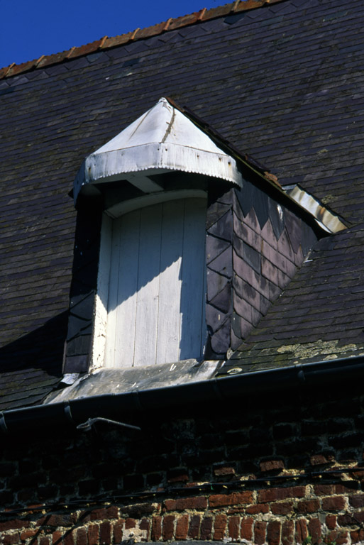 Détail de la lucarne qui surmonte la porte d'entrée.