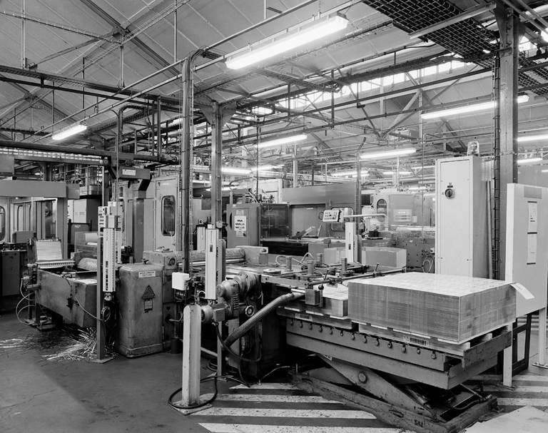 Intérieur de la ferblanterie : début de la chaîne de façonnage des boîtes en métal, à partir de plaques de métal imprimées.