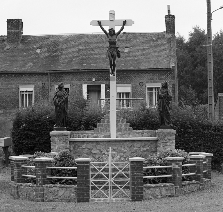 Rue de la Laiterie, rue de Bergues : calvaire composé de statues provenant de l'Union artistique de Vaucouleurs (1954). ; Boué (rue de la Laiterie, rue de Bergues) : vue frontale du calvaire (1954) composé de statues provenant de l'Union artisttique de Vaucouleurs.