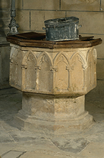 Vue d'ensemble des fonts baptismaux, en calcaire, datant du 13e siècle.