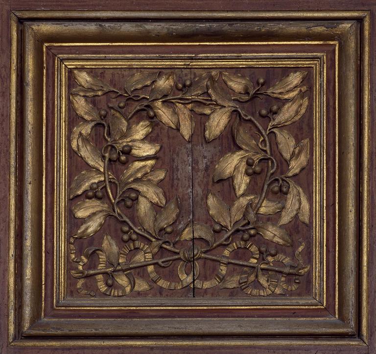 Détail des vantaux de l'armoire : panneau du registre supérieur représentant une couronne de laurier.