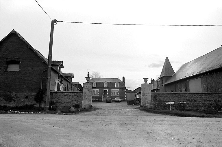 Vue d'ensemble de la ferme : logis du 18e siècle au fond, bâtiments agricoles et pigeonnier de part et d'autre de la cour.