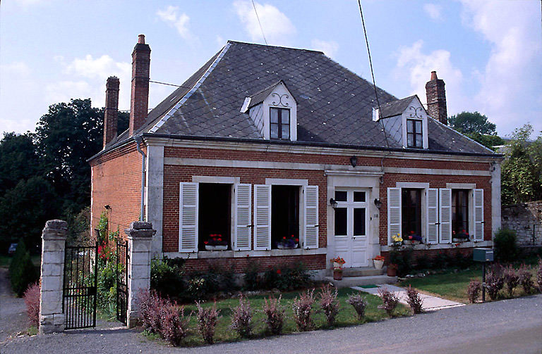 Vue de la maison, milieu 19e siècle, brique, façade avec solin, encadrement ouvertures, chaînage angles en pierre de taille, toit en pavillon ardoise synthétique.