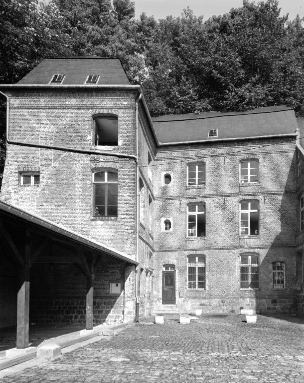 Vue de la façade de l'aile secondaire, à gauche, portant sur le mur arrière aveugle la date de 169[?] en briques vernissées.