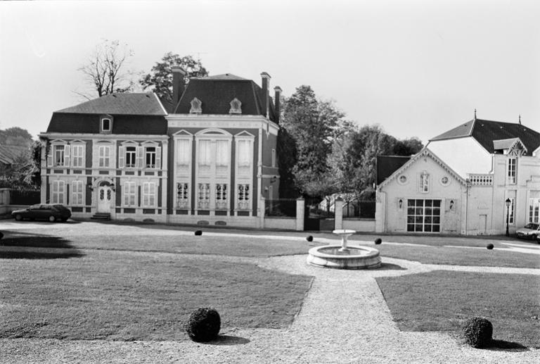Vue de l'ancienne cour transformée en jardin en 1989, avec la maison patronale à gauche et l'ancienne remise à droite.