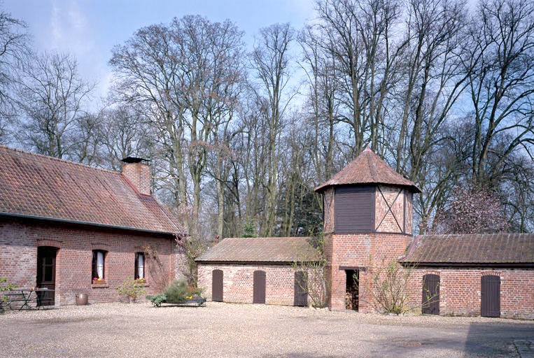 La ferme du château : vue du logis et des étables avec pigeonnier en briques.