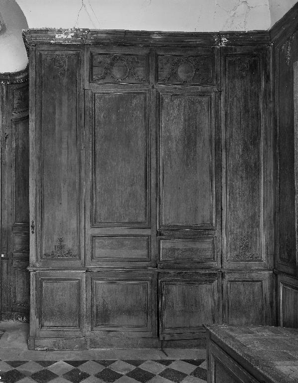 Vue des lambris du mur nord et des battants d'un placard encastré.