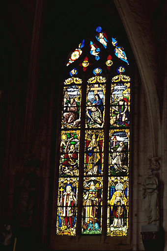 Verrière figurée (baie 2) : saint Louis, saint Ambroise, saint Denis, saint Hubert, saint évêque, saint François d'Assise, saint Antoine, Vierge de Pitié, saint Jérôme, ange aux instruments de la Passion