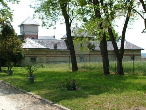 Vue depuis l'extérieur de la propriété des bâtiments agricoles surmontés du pigeonnier.