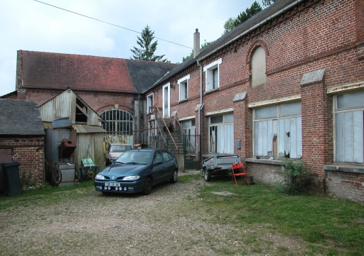 Façade sur cour de l'atelier de fabrication et charreterie en retour.