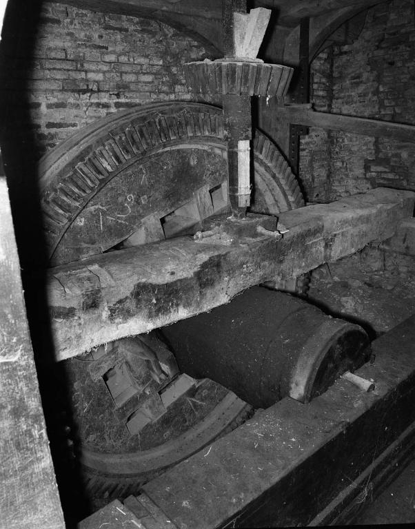 Vue intérieure du moulin, engrenage et axe de transmission de la force hydraulique.