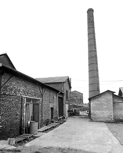 Ateliers de fabrication et cheminée d'usine, vue depuis la cour.