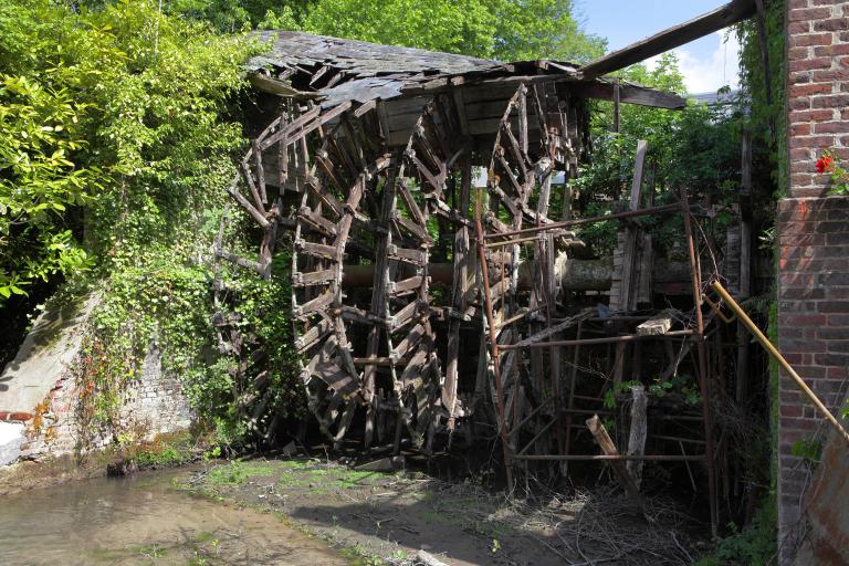 La roue hydraulique du moulin du Chapitre réutilisée par l'usine de jouets Euréka de Douville-sur-Andelle était par ses dimensions (6 m de largeur et 4 m de diamètre) et sa force de 120 000 kWh, l'une des plus puissantes du territoire. ; Vue d'ensemble depuis l'aval. ; Roue par-dessous du moulin du Chapitre établi à Douville-sur-Andelle.