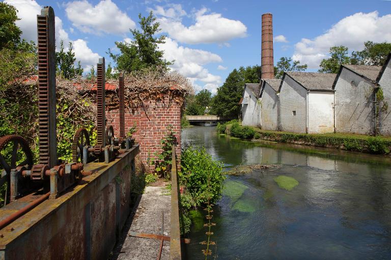 Vue d'ensemble du canal d'amenée, de la filature et de la cheminée, depuis les vannes de décharge au sud.