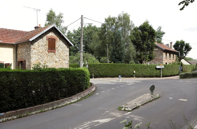 Vue partielle de la maison de garde-barrière (au premier plan) et vue de la gare (à l'arrière plan).