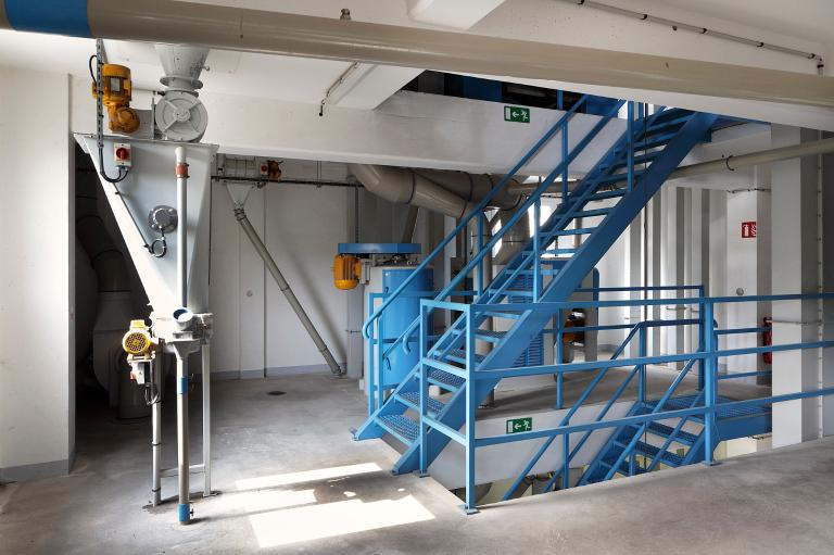 Vue intérieure de la minoterie moderne : trémie et escalier de distribution.