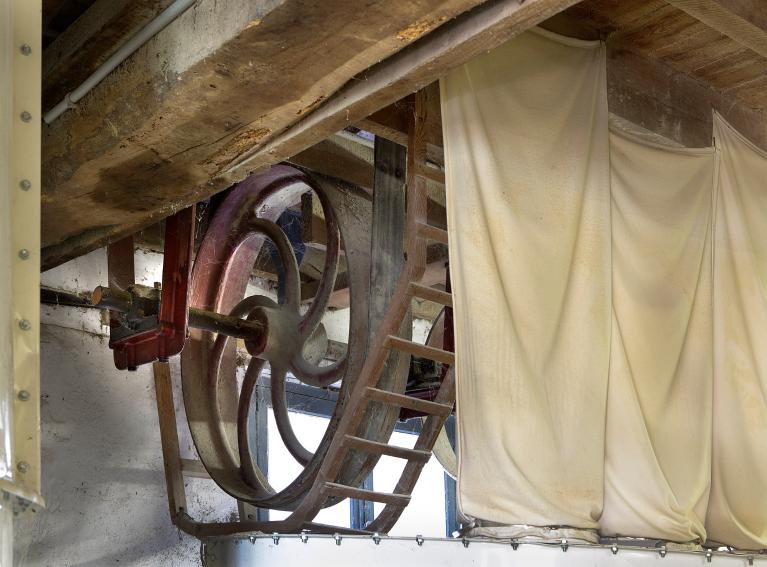 Vue intérieure du moulin primitif : axe de transmission de l'énergie produite par la turbine.