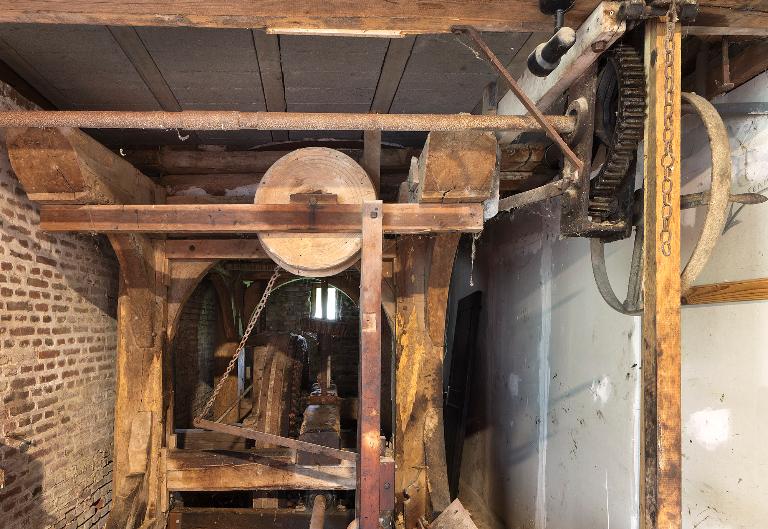 Vue intérieure du moulin : beffroi, engrenage et axe de transmission.