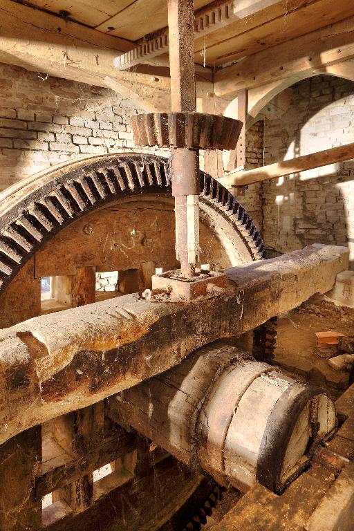 Vue intérieure du moulin : engrenage et axe de transmission.