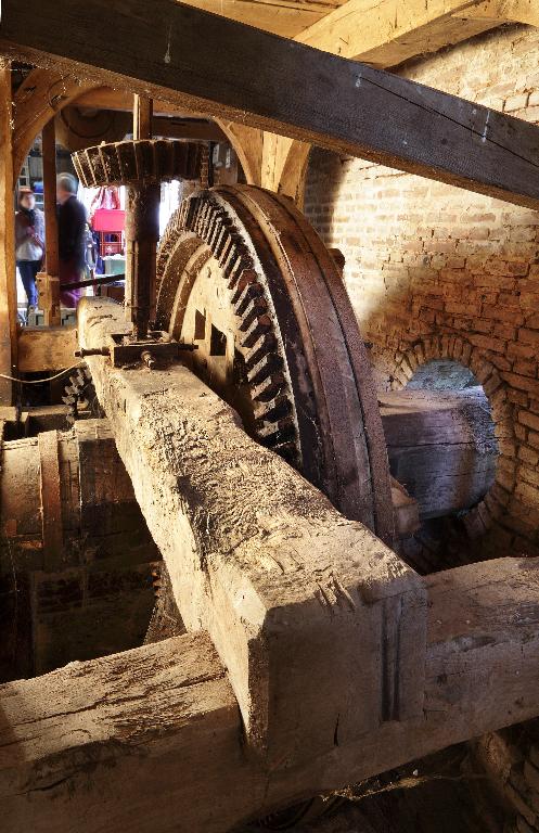 Vue intérieure du moulin : engrenage et axe de transmission.