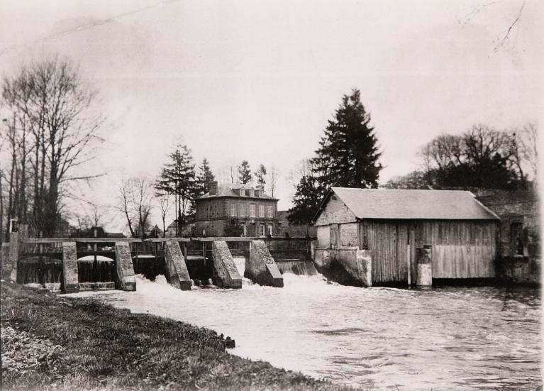 Vue depuis la rive droite de l’Andelle : barrage et logement du PDG avant transformation, vers 1920 (Collection particulière).
