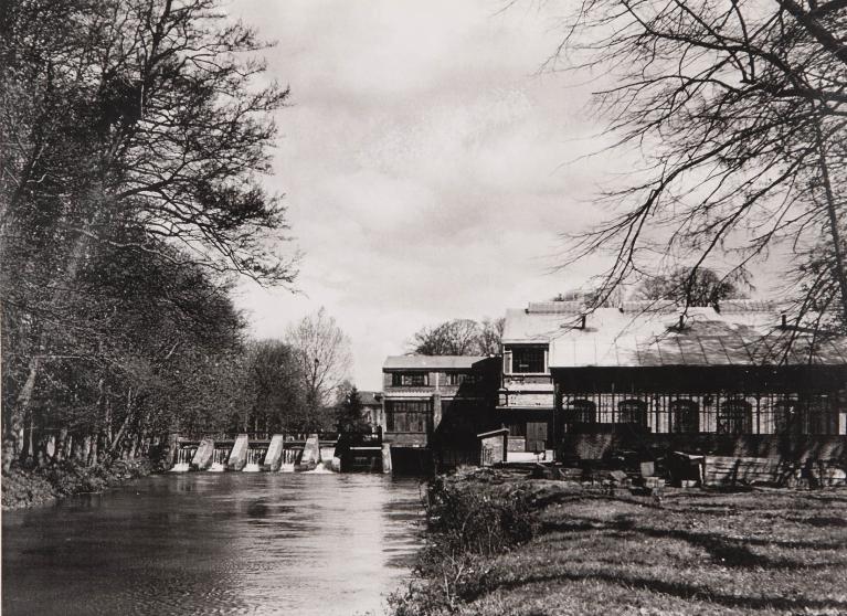 Vue de l’usine et du cours principal de l’Andelle avec le barrage, depuis l’aval à l’extrémité de l’île de Bacqueville, vers 1950 (Collection particulière).