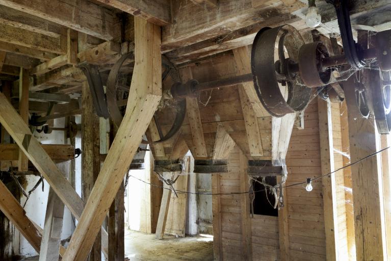 Minoterie, vue intérieure du troisième étage : axe de transmission de l'énergie, trémies et silo à grain.