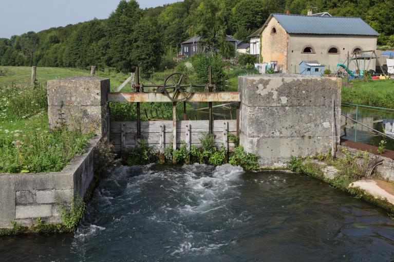 Vue depuis le sud du bief et du vannage d'alimentation avec à l'arrière un bâtiment annexe vestige de l'ancienne filature.