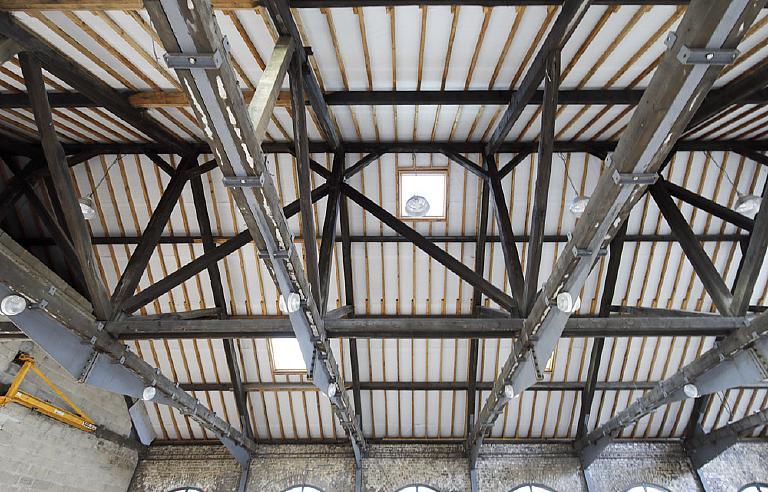 Atelier de mécanique de la taillanderie en cours de reconversion en logement, vue intérieure, détail de la charpente en bois d'origine.