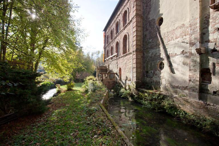 Vue d'ensemble du canal d'amenée (à droite), du canal de décharge (à gauche) et de la façade est de la minoterie.