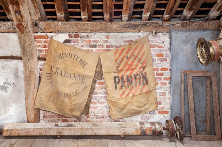 Vue intérieure de la minoterie, étage de comble, sacs à farine.
