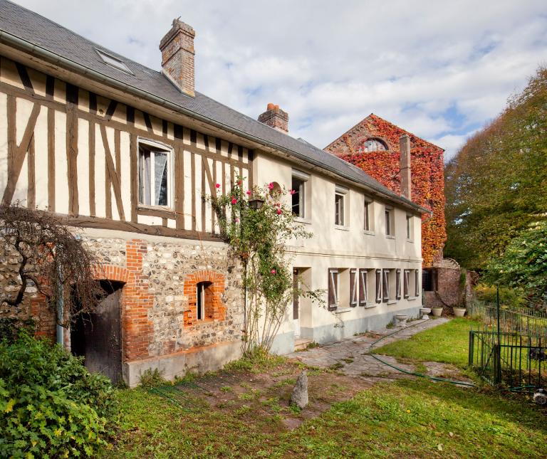 Vue générale de la remise et du logis (au premier plan) et du pignon sud de la minoterie (à l'arrière plan), depuis la berge du canal de fuite.